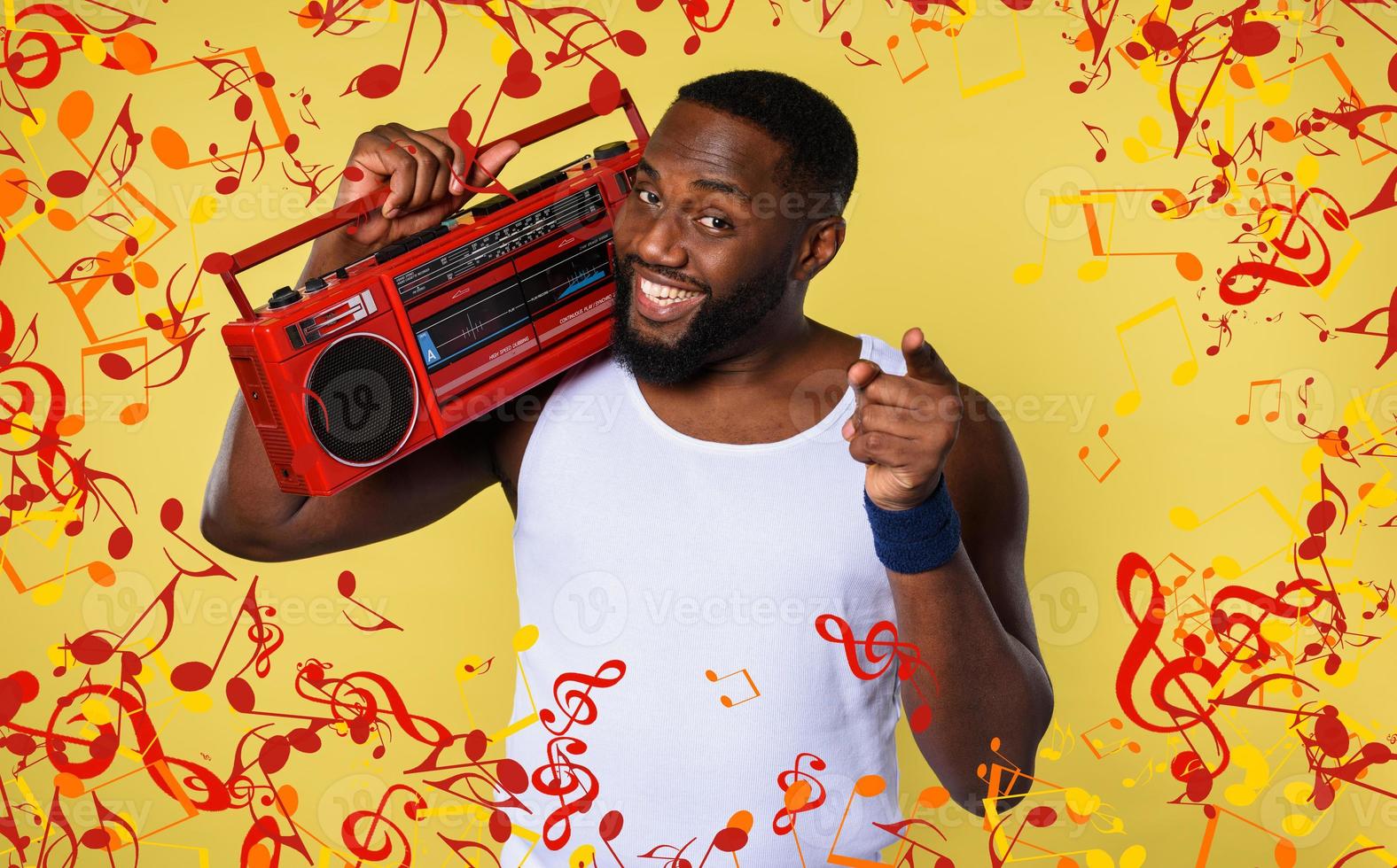 Man ears the music with an old stereo and dances. emotional and energetic expression. yellow background photo