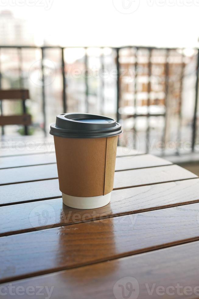 take away paper coffee cup o on cafe table photo