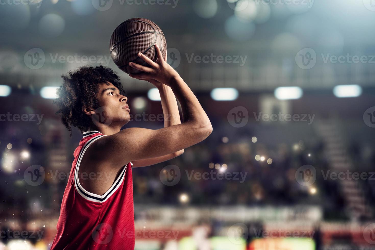 Basketball player throws the ball in the basket in the stadium full of spectators photo