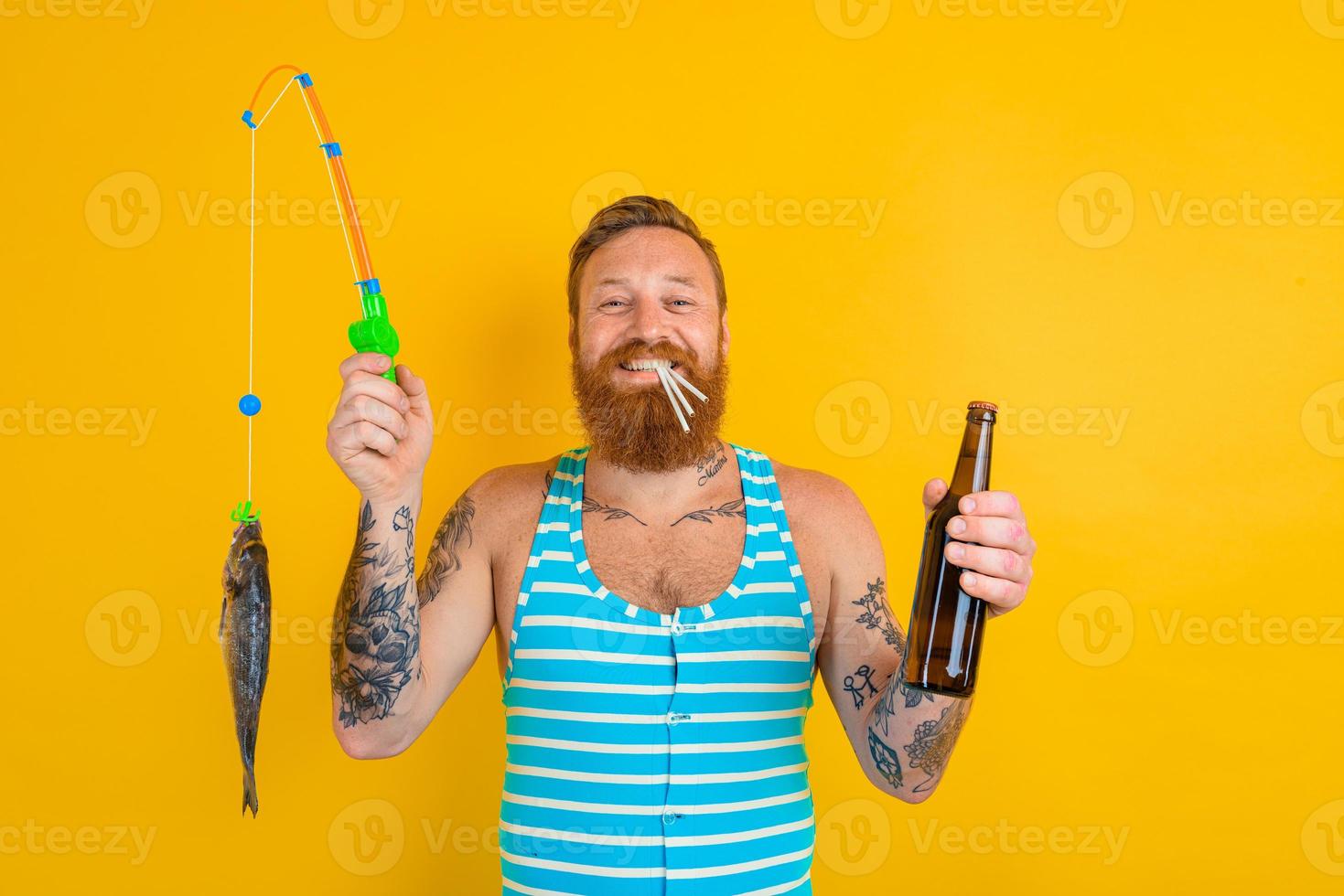 man with beard and swimsuit caught a fish photo