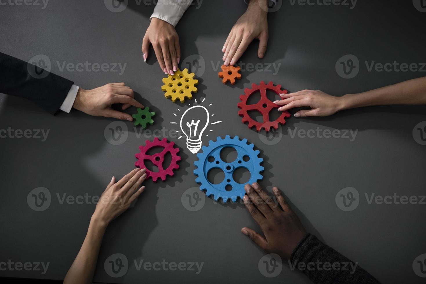 Business team connect pieces of gears to build a new creative idea. Teamwork, partnership and integration concept photo