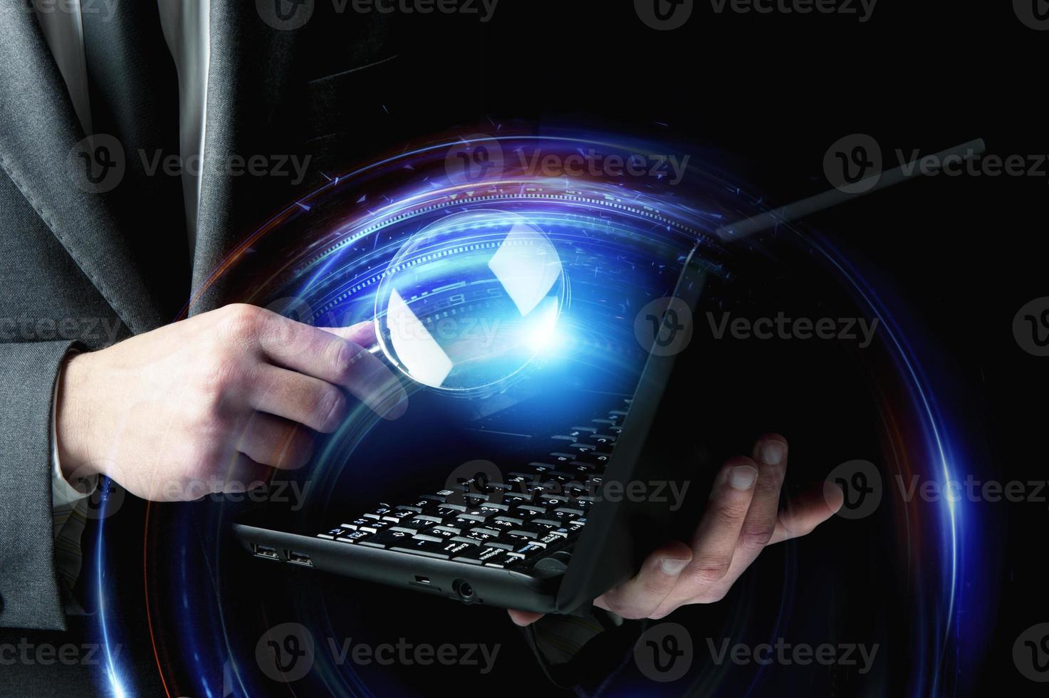 Businessman examines a laptop with a magnifying glass. Concept of internet security. photo