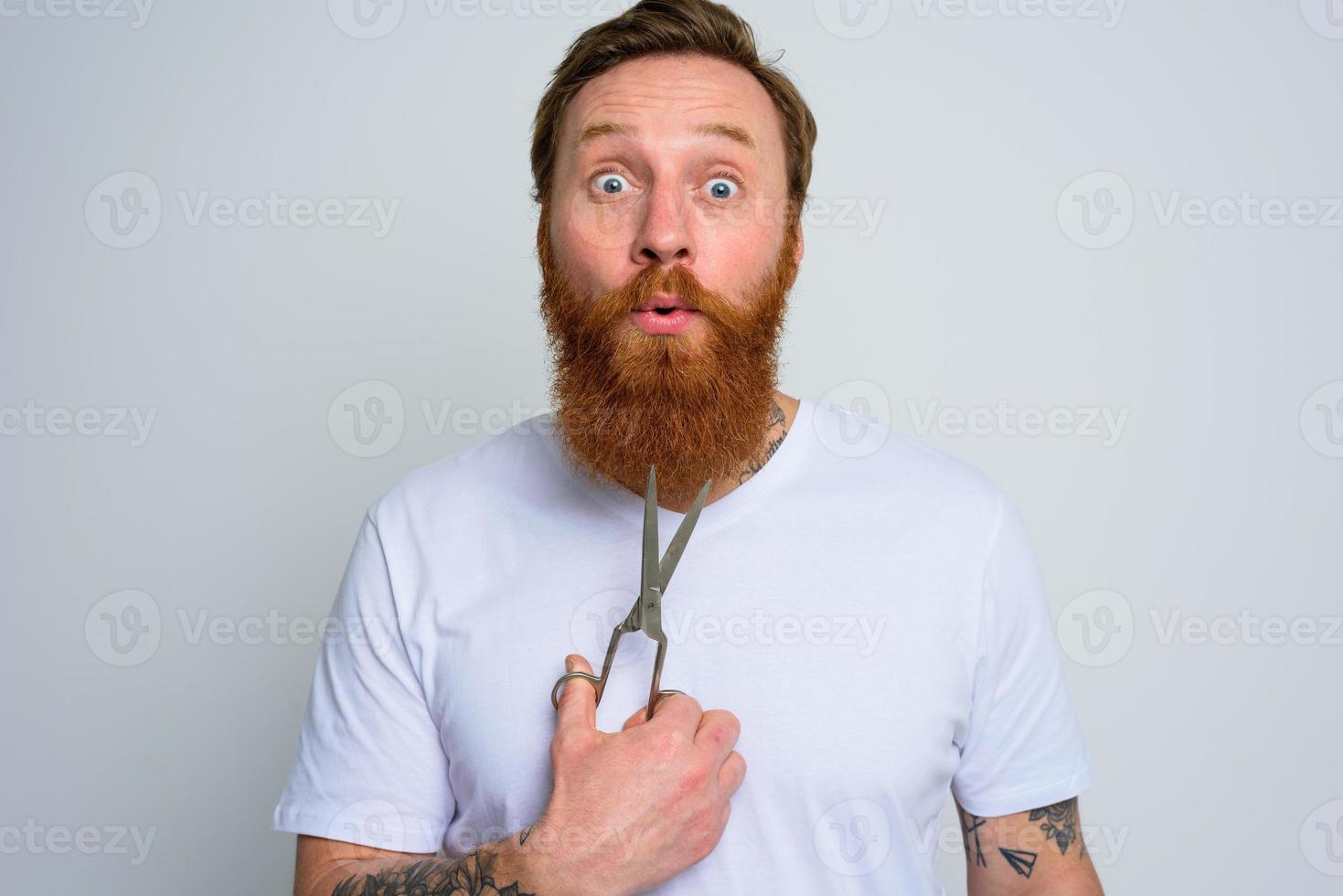 Wondered man with scissors is ready to cut the beard photo