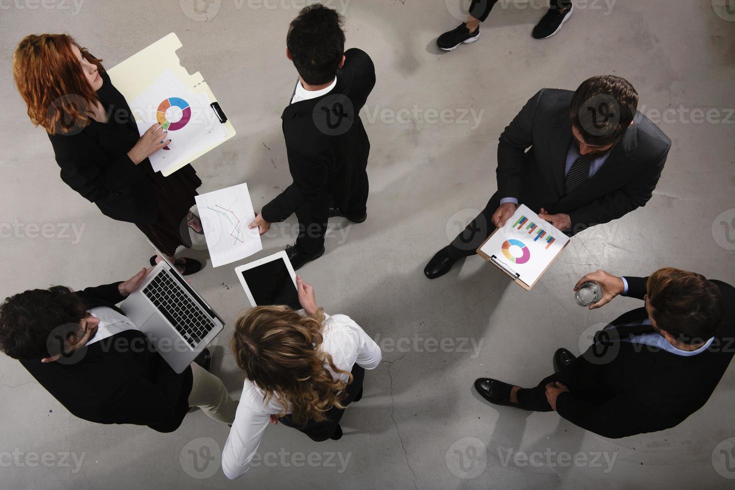 Team of business person works together on company statistics. Shooted from above. Concept of teamwork and partnership photo