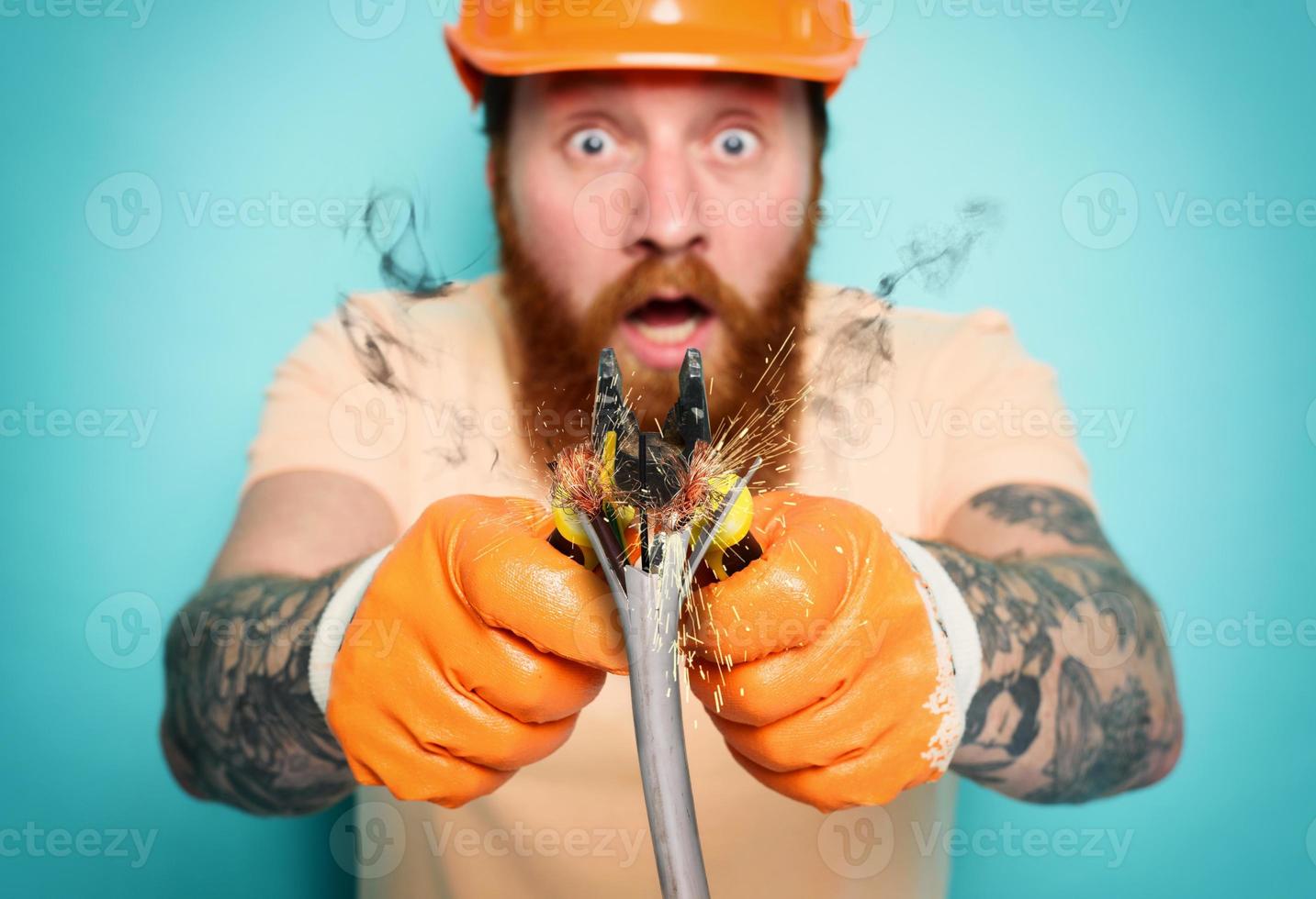 Incompetent worker electrician is unsure about his work. cyan background photo