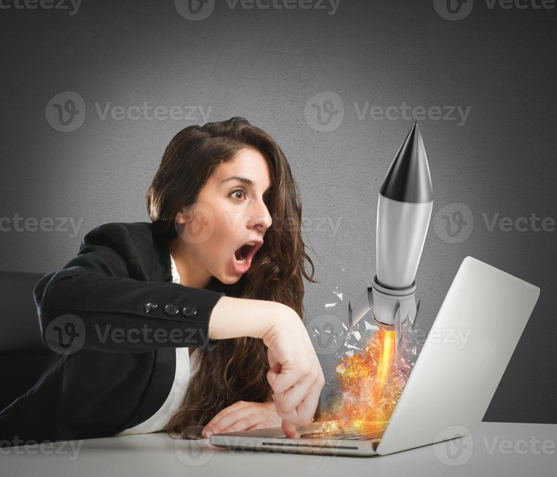 Businesswoman launches rocket from a laptop. concept of company startup photo