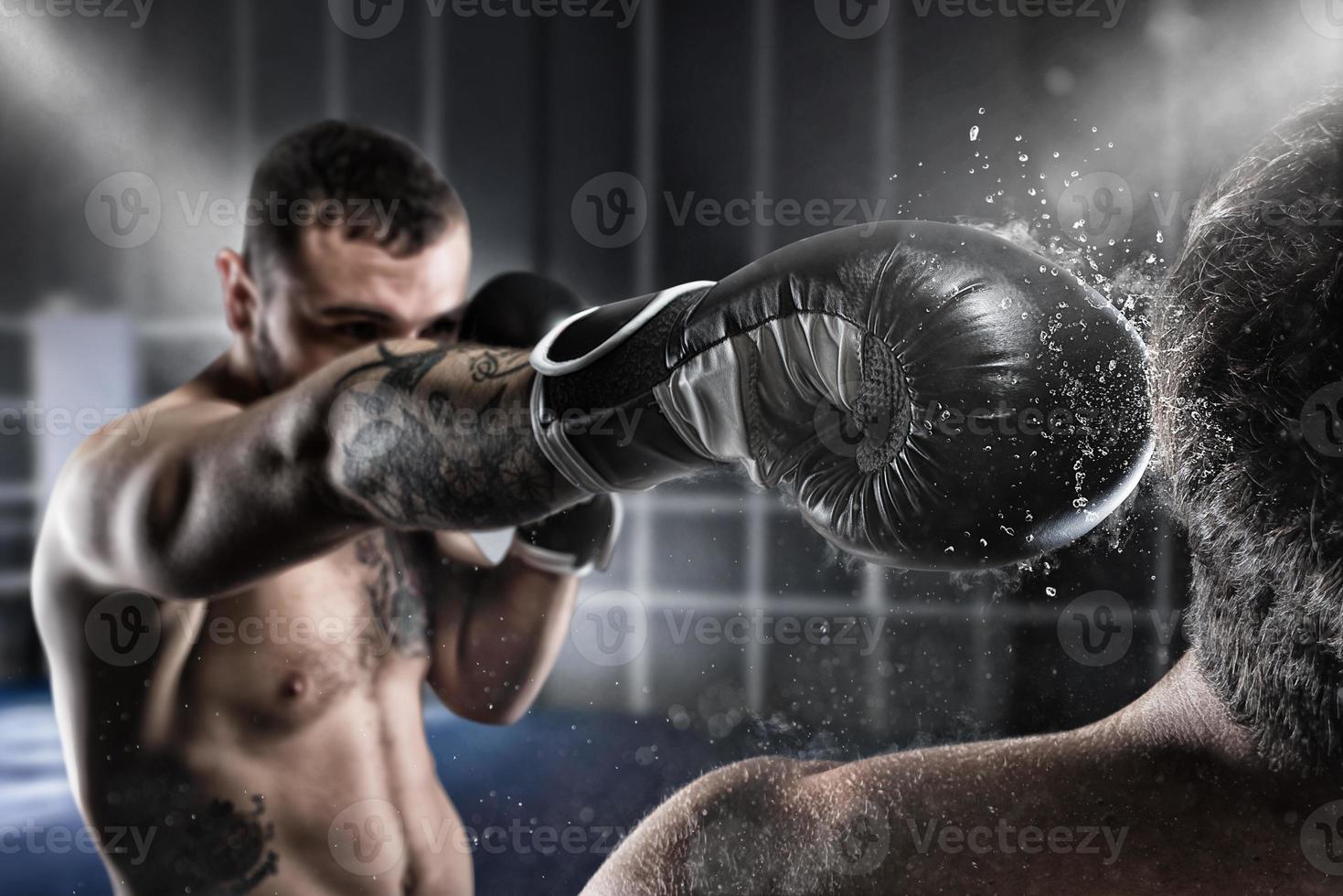 Boxer in a boxe competition beats his opponent photo