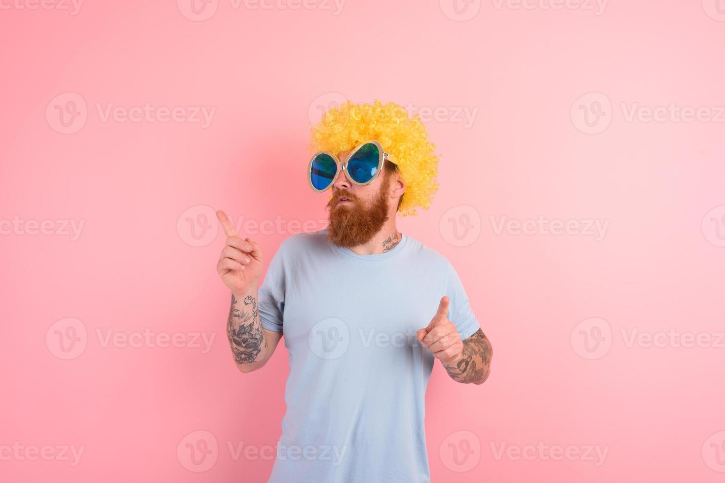 Funny serious man with peruke and sunglasses dances photo