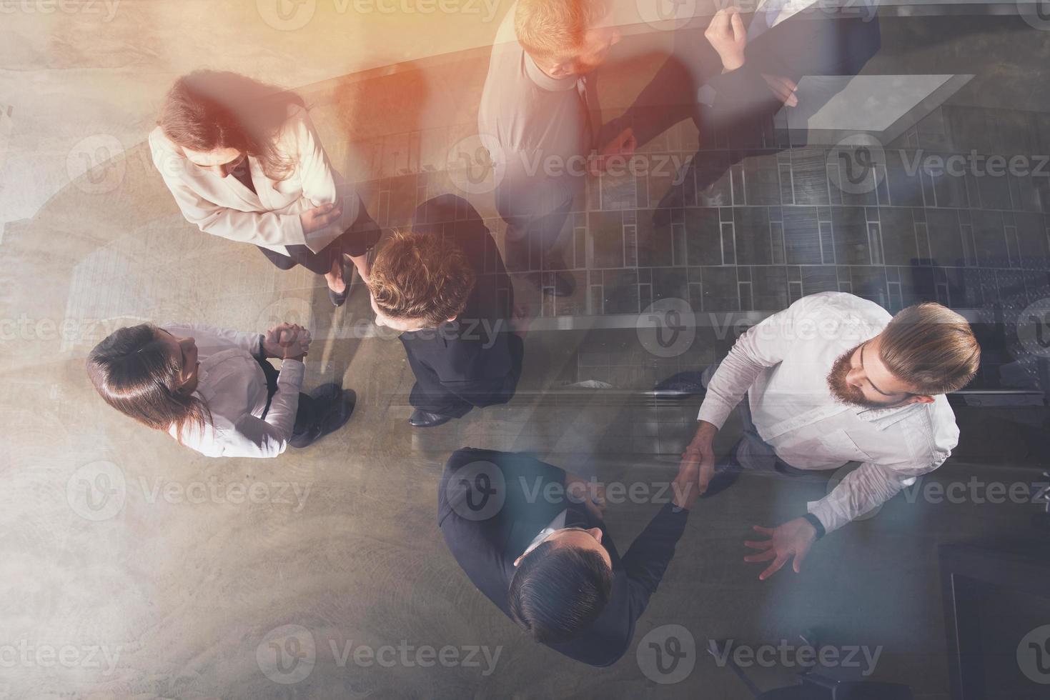 Handshaking business person in office. concept of teamwork and partnership. double exposure photo