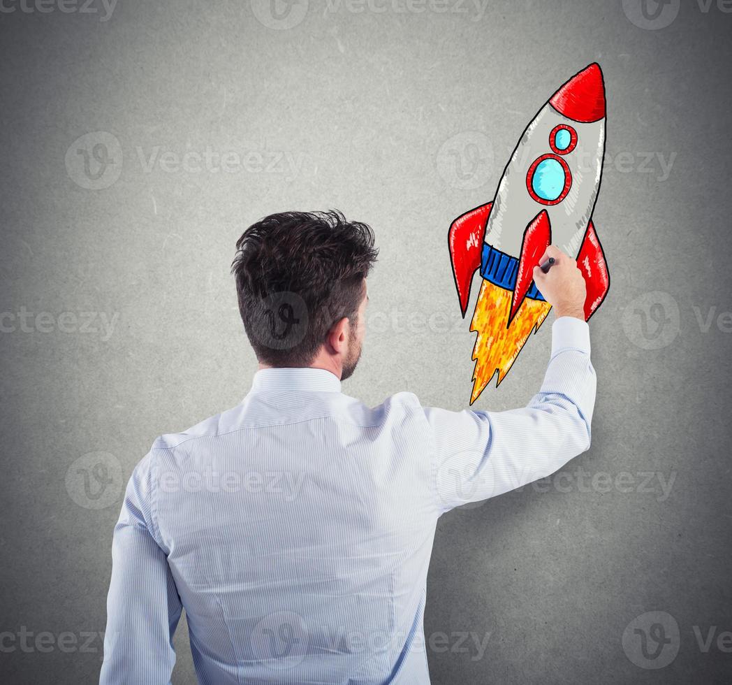 Businessman drawing a rocket. Concept of business improvement and enterprise startup photo