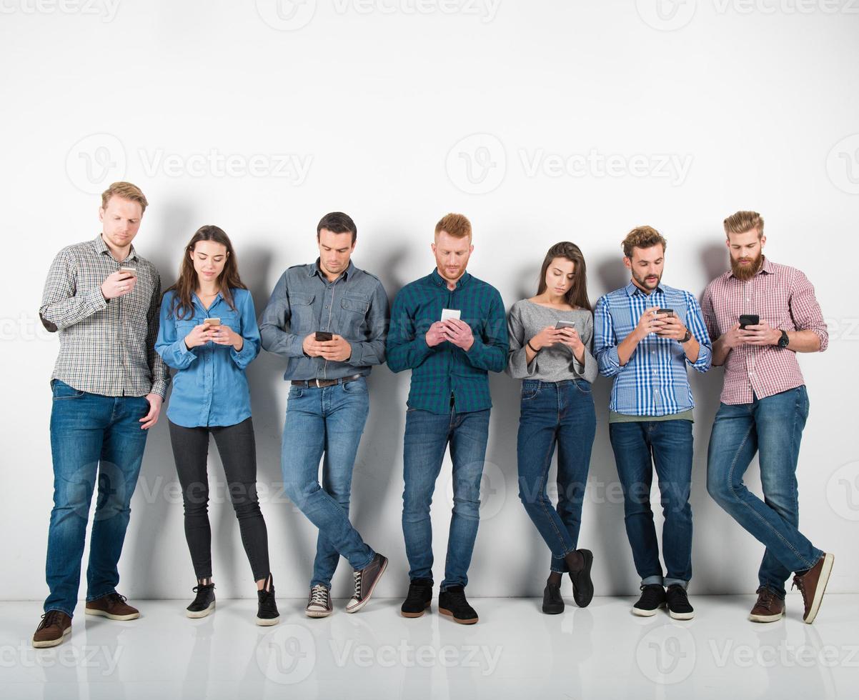 Group of boys and girls connected with their smartphones. Concept of internet and social network photo