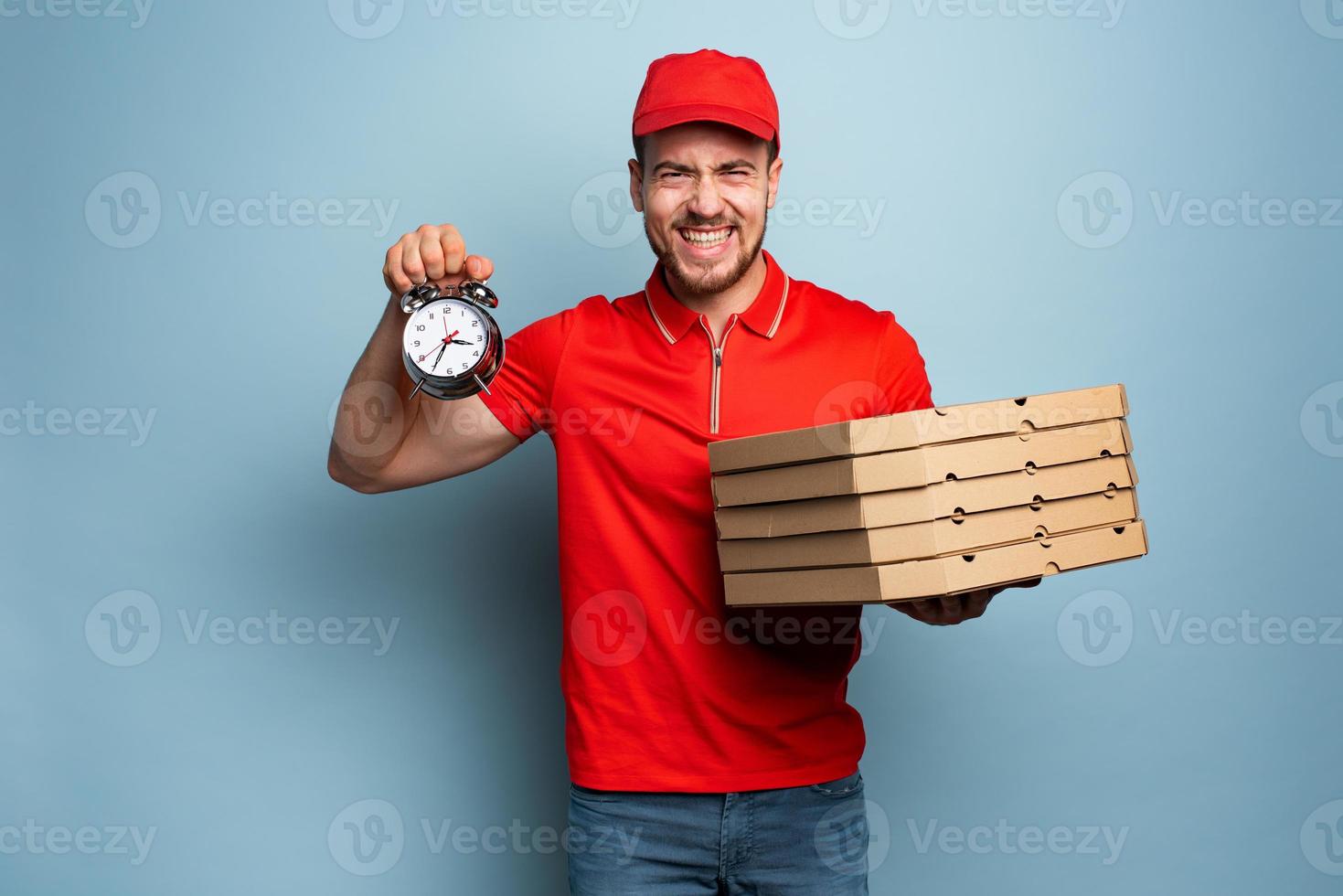 Deliveryman is punctual to deliver quickly pizzas. Cyan background photo