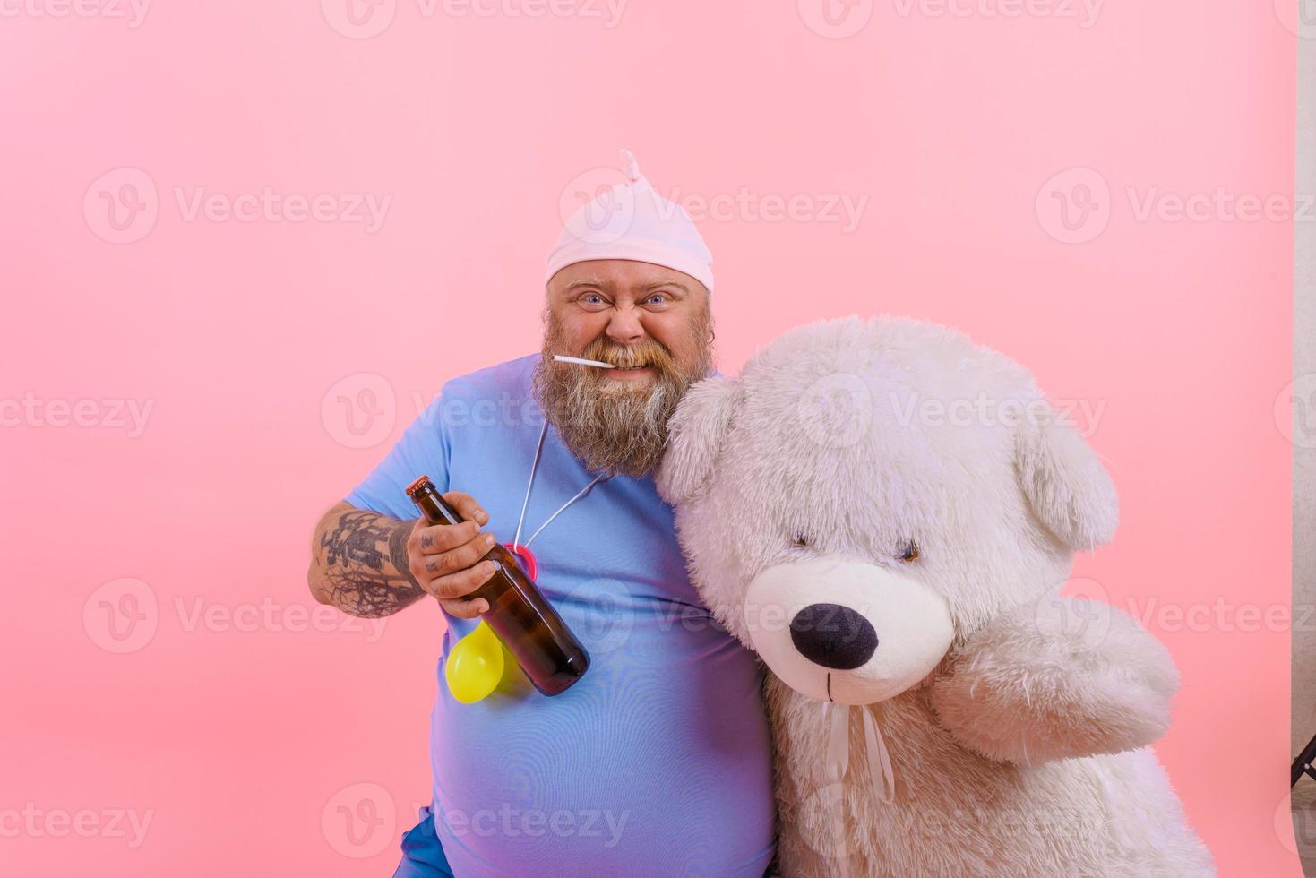 Fat happy man acts like a happy baby but drinks beer photo