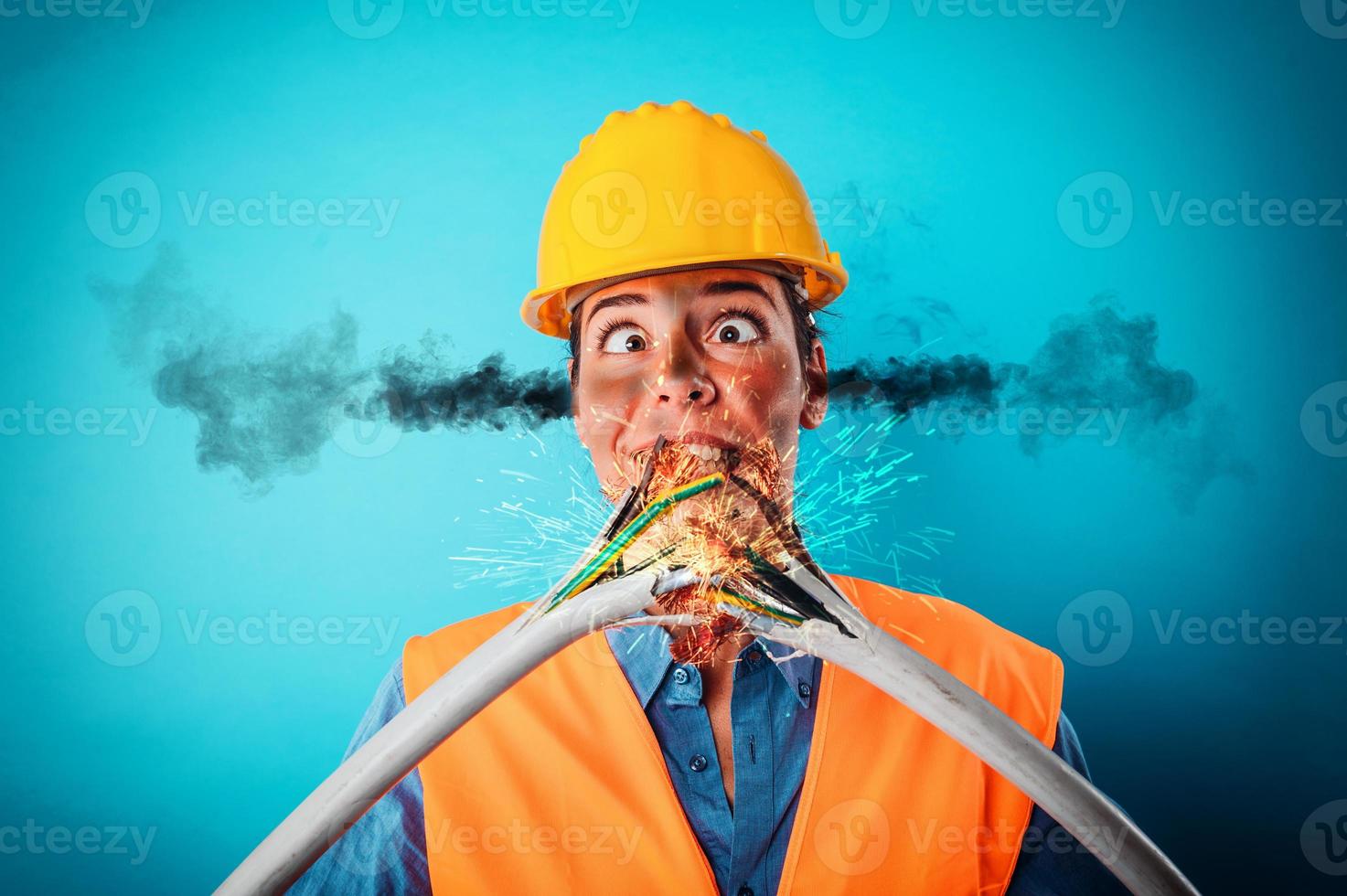 Shocked worker girl with helmet breaks an electric cable photo