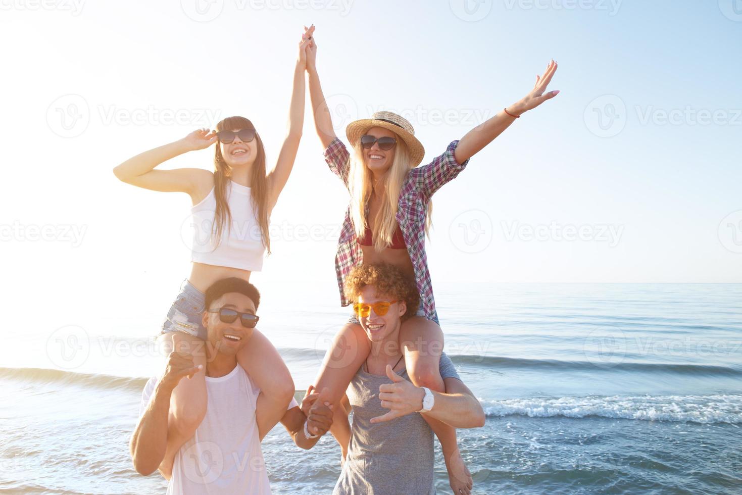 Happy smiling couples playing at the beach photo