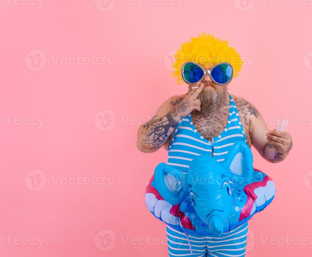 Fat serious man with beard and wig smokes cigarettes photo