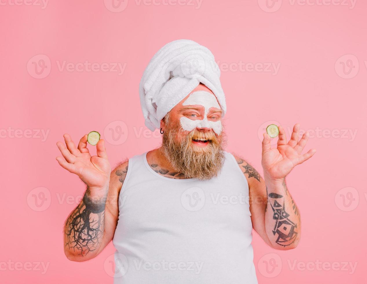 Man with beard acts like a woman and has fun with a facial mask photo