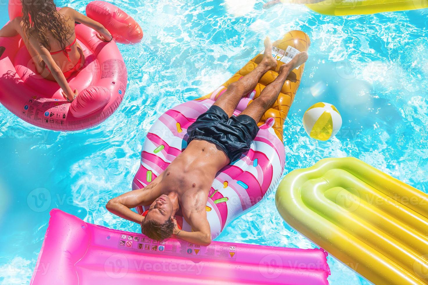 amigos en traje de baño en el piscina consiguiendo un bronceado foto