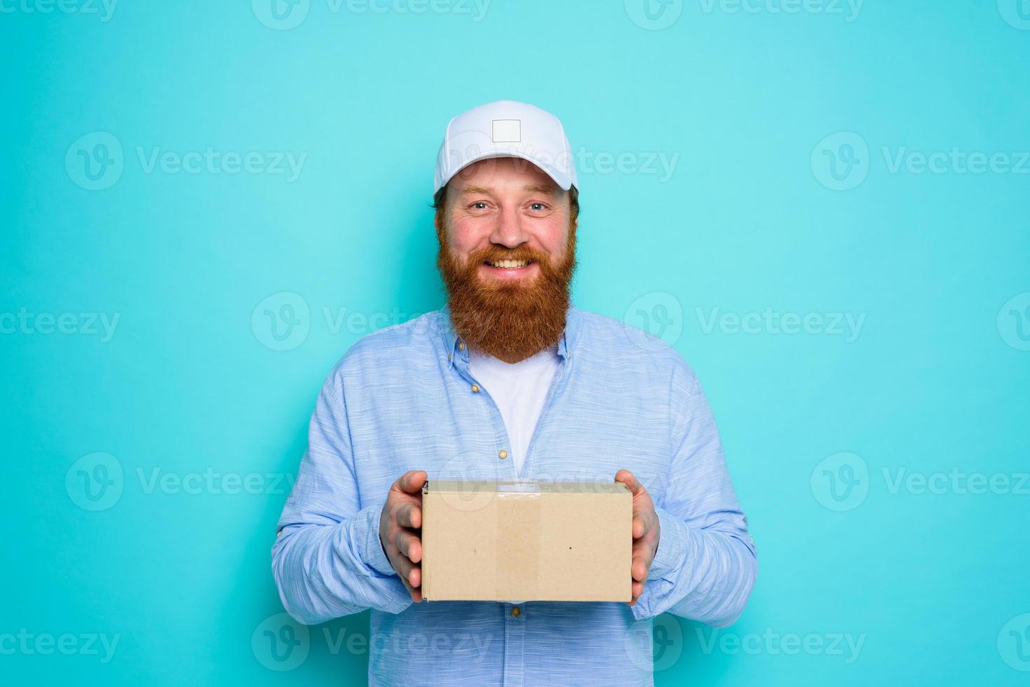 Courier with hat is happy to deliver a carton box photo