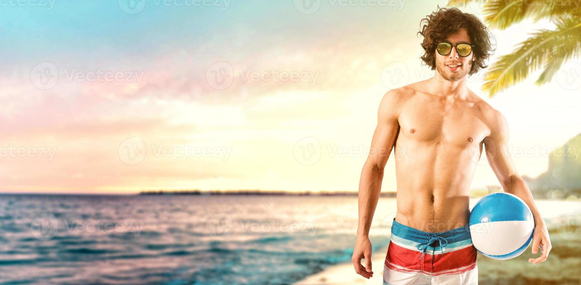 Beautiful boy with a ball at the beach at sunset. Relaxation and fun concept photo