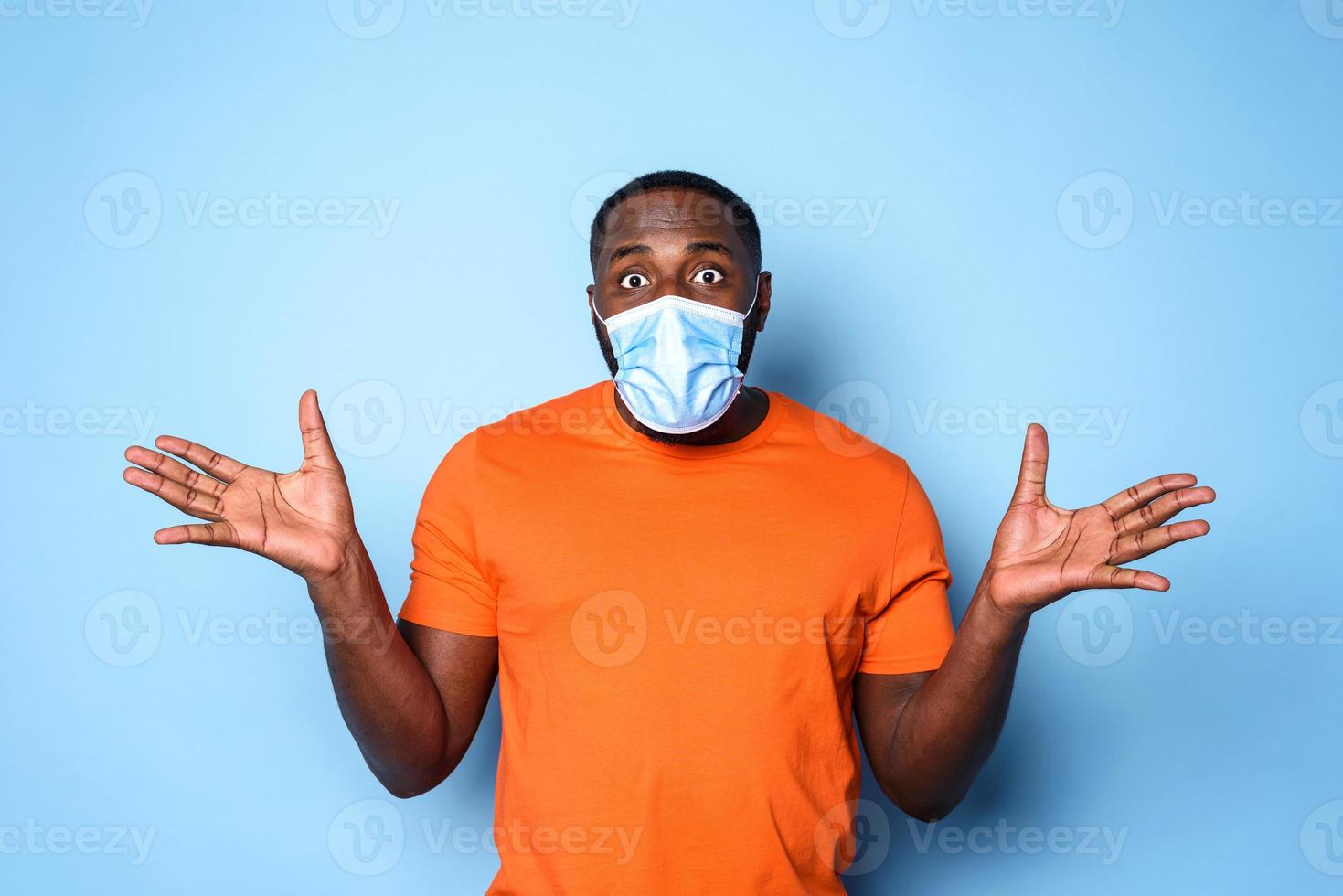 Boy with face mask has a lot of question about covid 19. cyan background photo