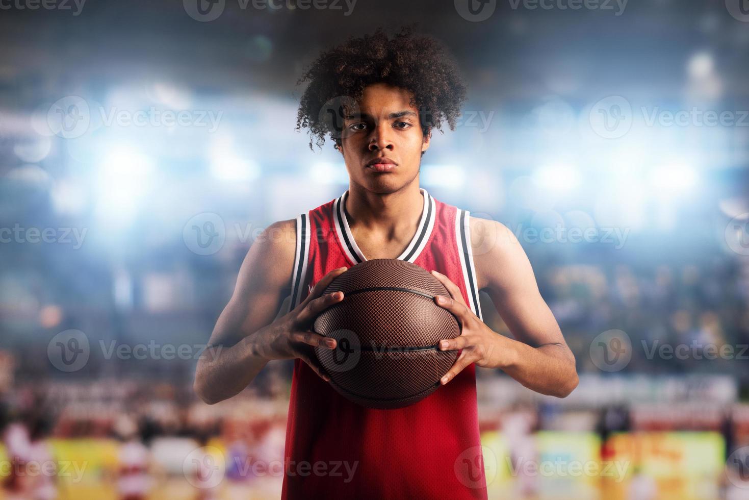 baloncesto jugador sostiene el pelota en el cesta en el estadio lleno de público. foto