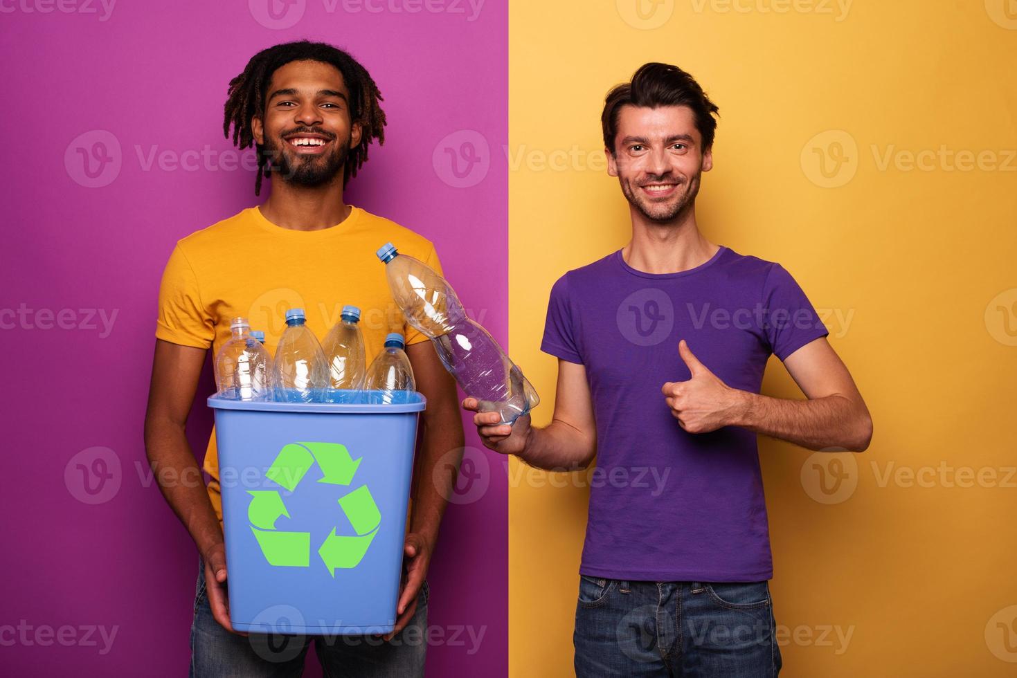 Friends hold a plastic container with bottles over yellow and purple color. Concept of ecology, conservation, recycling and sustainability photo