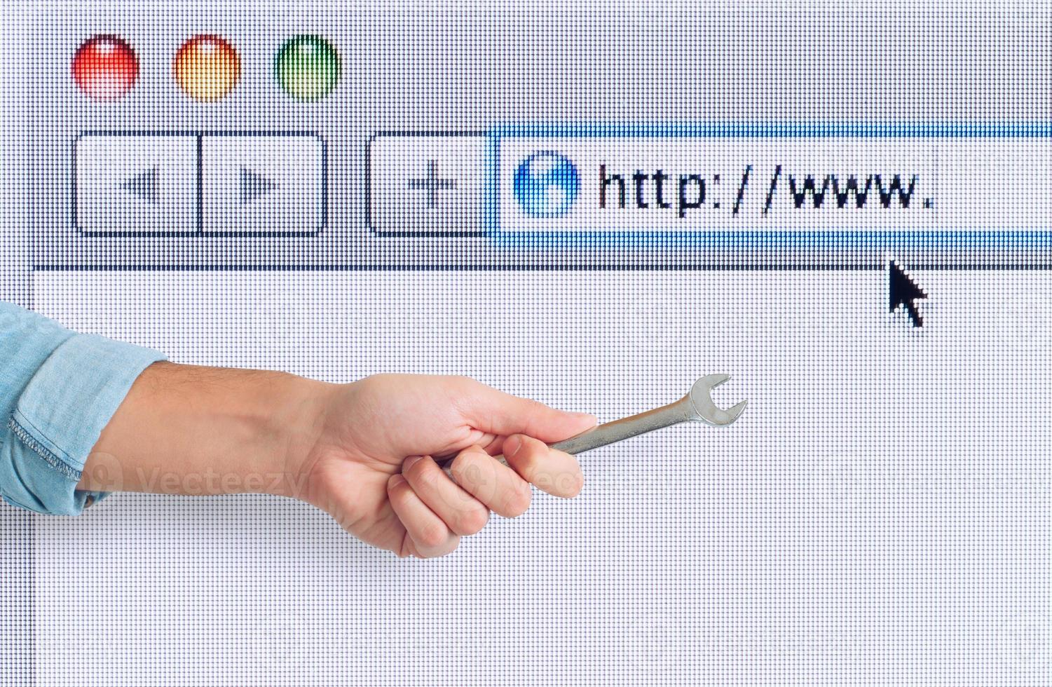 Hand with wrench over a internet web browser. concept of fix errors photo