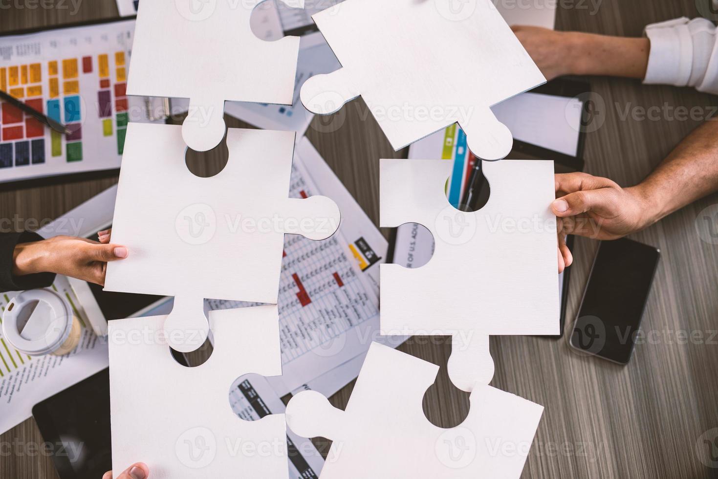 trabajo en equipo de socios. concepto de integración y puesta en marcha con rompecabezas piezas foto