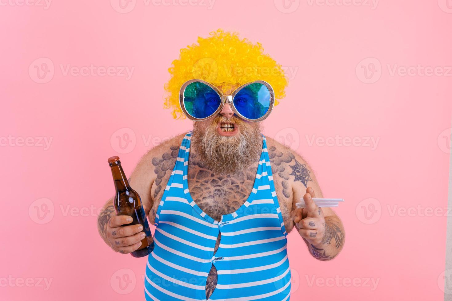 Fat man with beard and wig smokes cigarettes and drinks beer photo