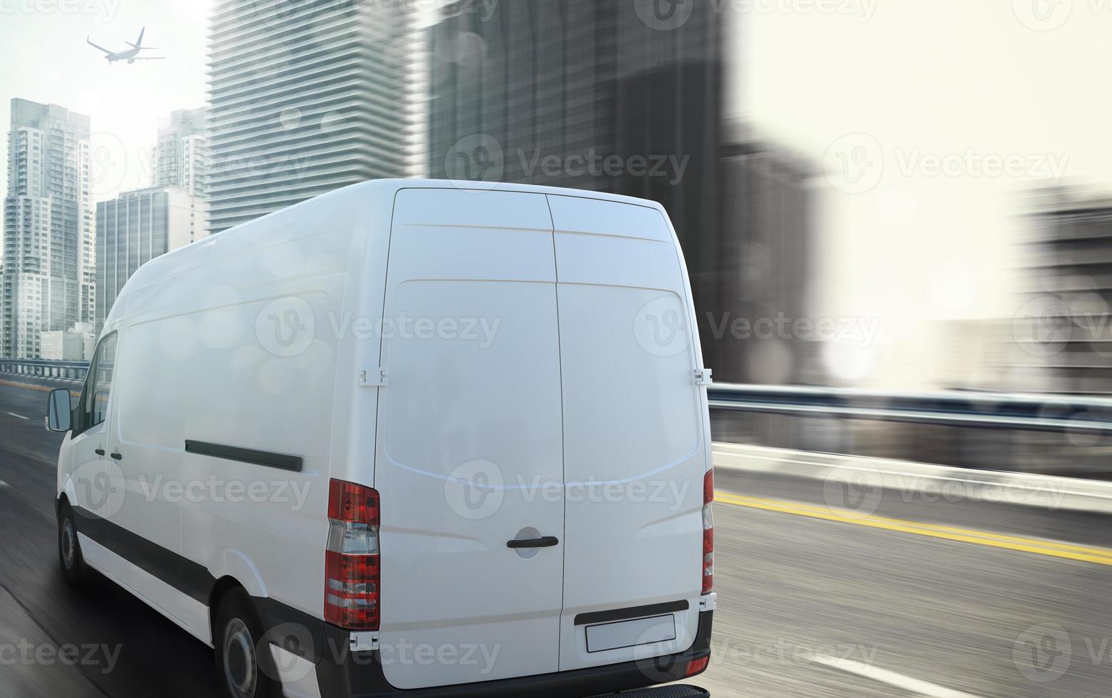 White van moving fast on the highway with a modern city in the background photo