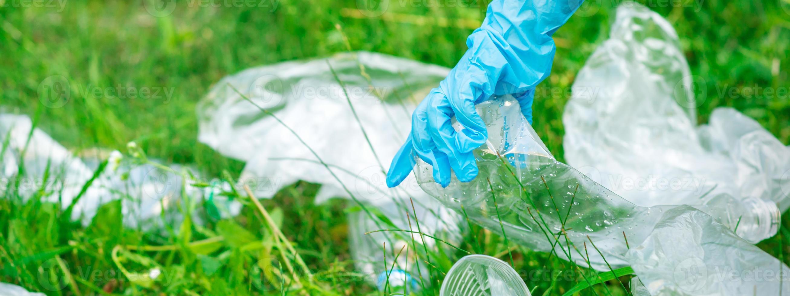 Hand of child cleans the park from plastic debris photo