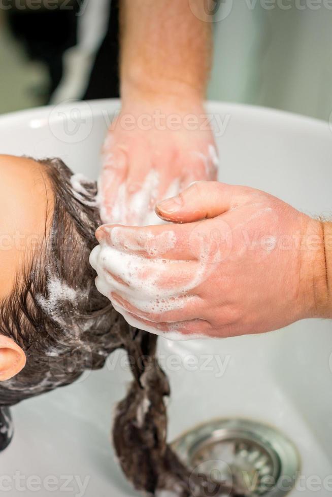 Young woman gets hair wash photo