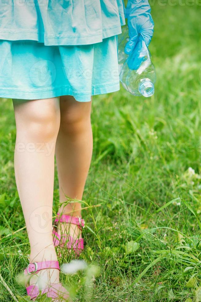 niña con botella de plástico arrugada foto