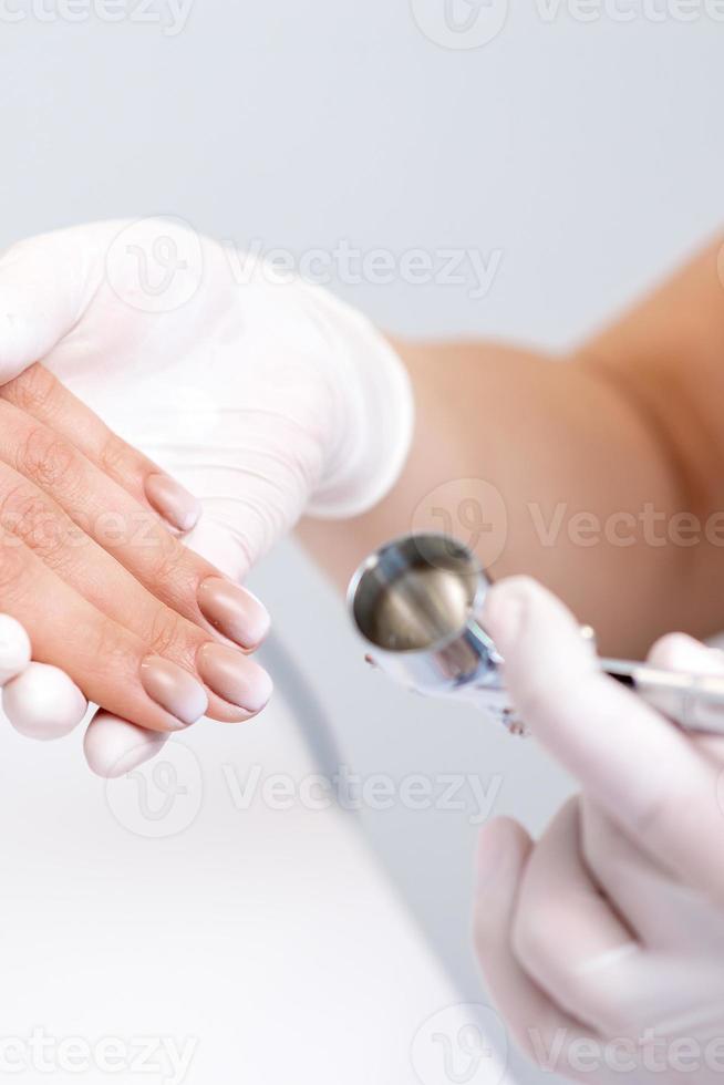 mujer recepción manicura por aerógrafo foto