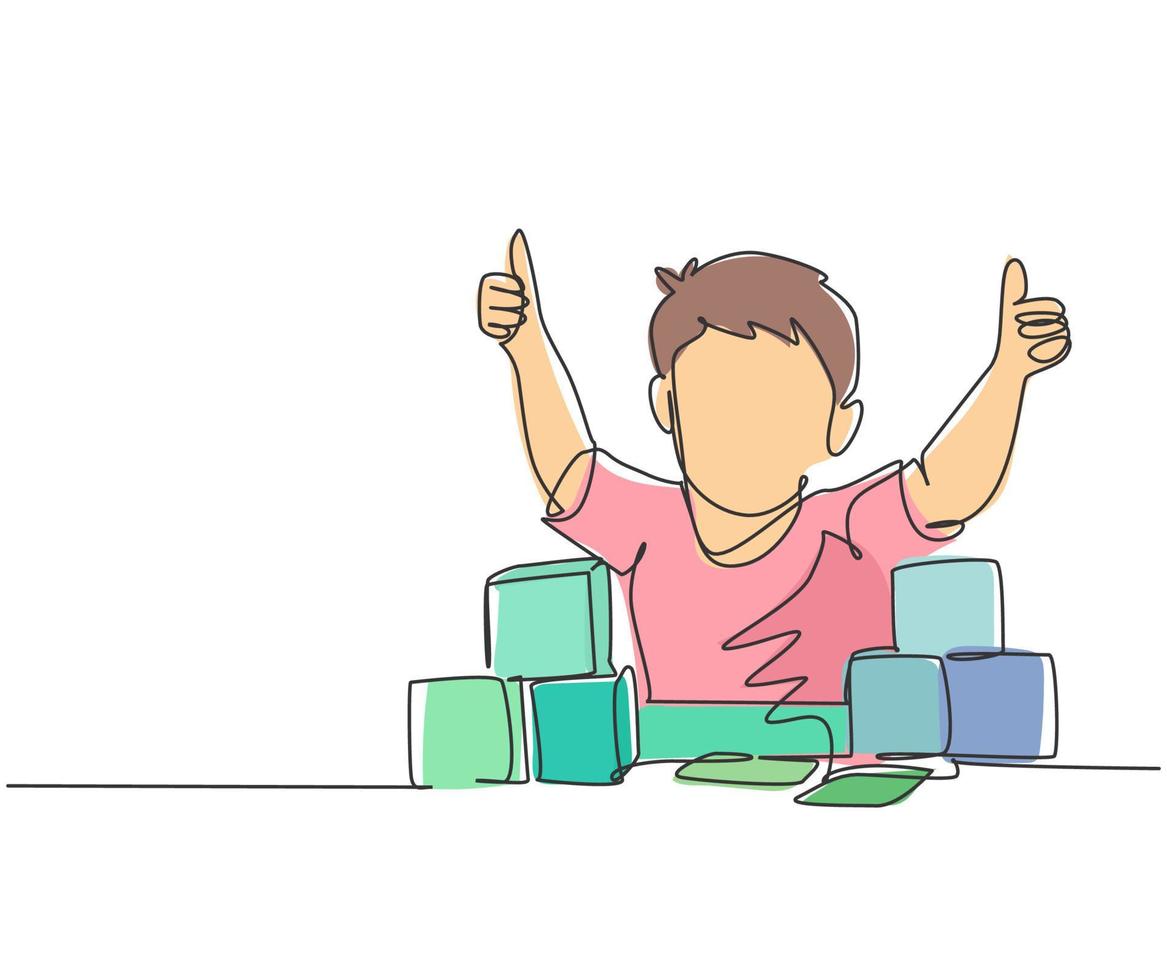 Single line drawing of young happy boy playing stack of puzzle block on table and giving thumbs up gesture in kindergarten class. Business deal continuous line draw design graphic vector illustration