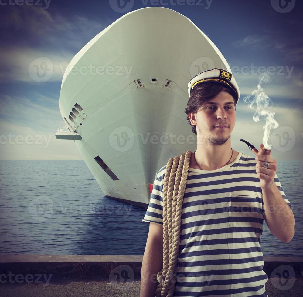 Sailor smokes in front of ship photo
