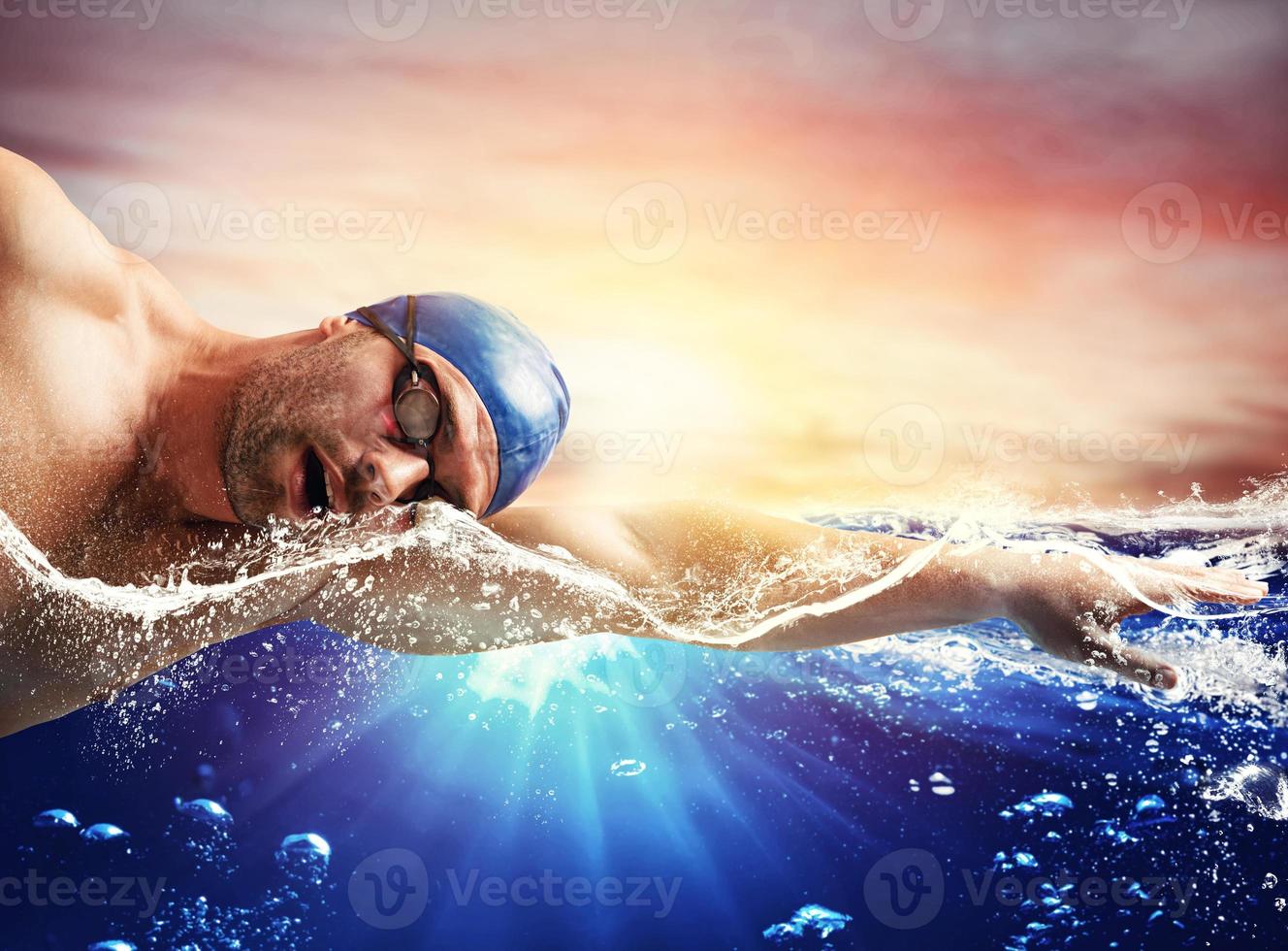 Boy swims in a blue deep water photo