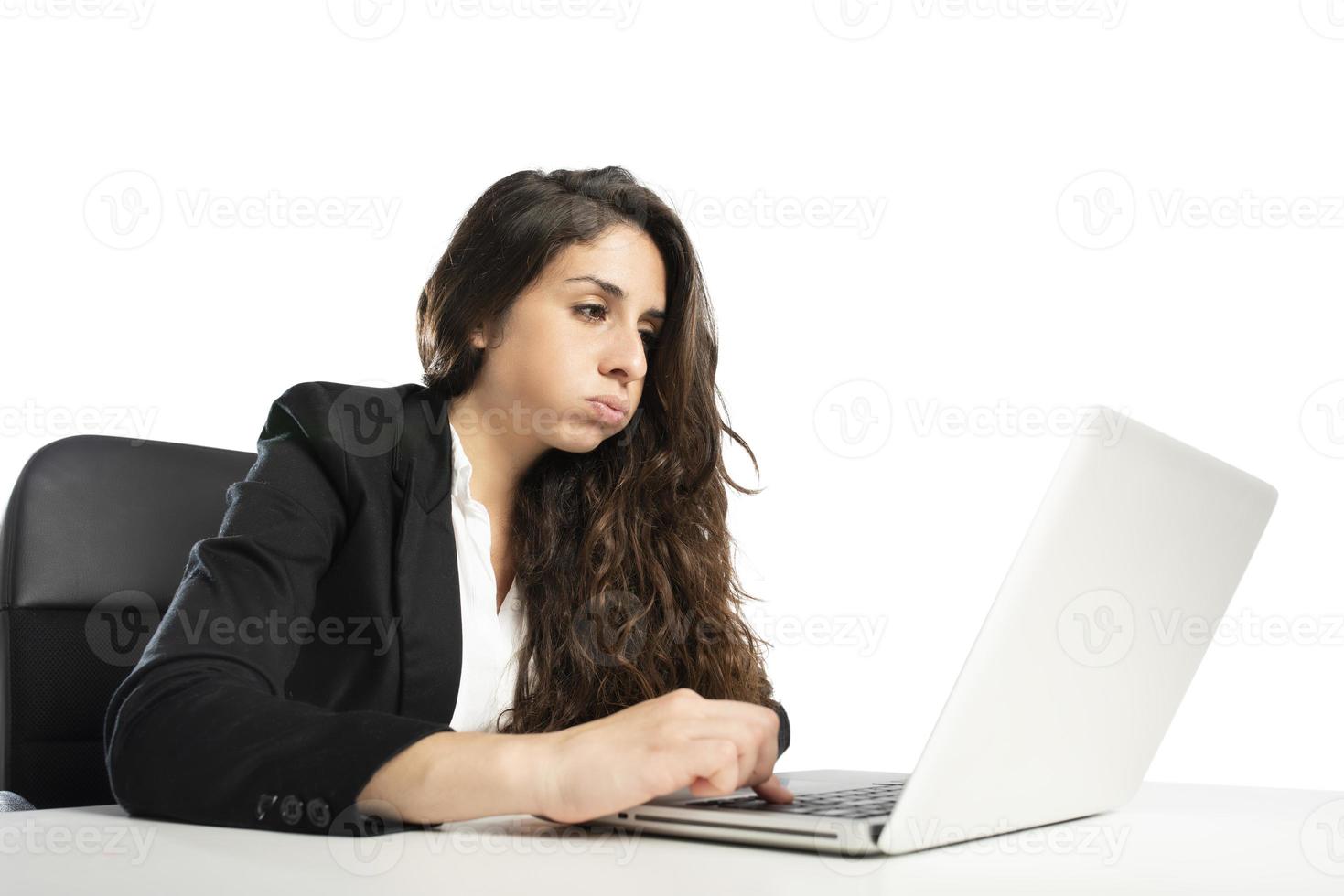 Bored woman snorts in the office while working on the laptop photo