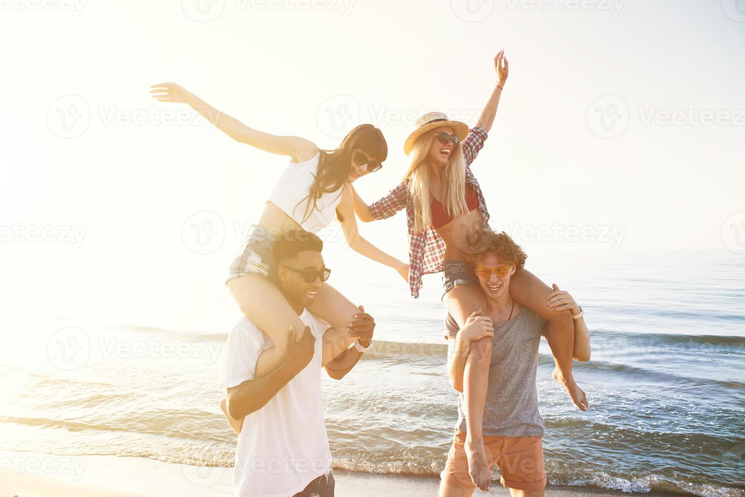 Happy smiling couples playing at the beach photo