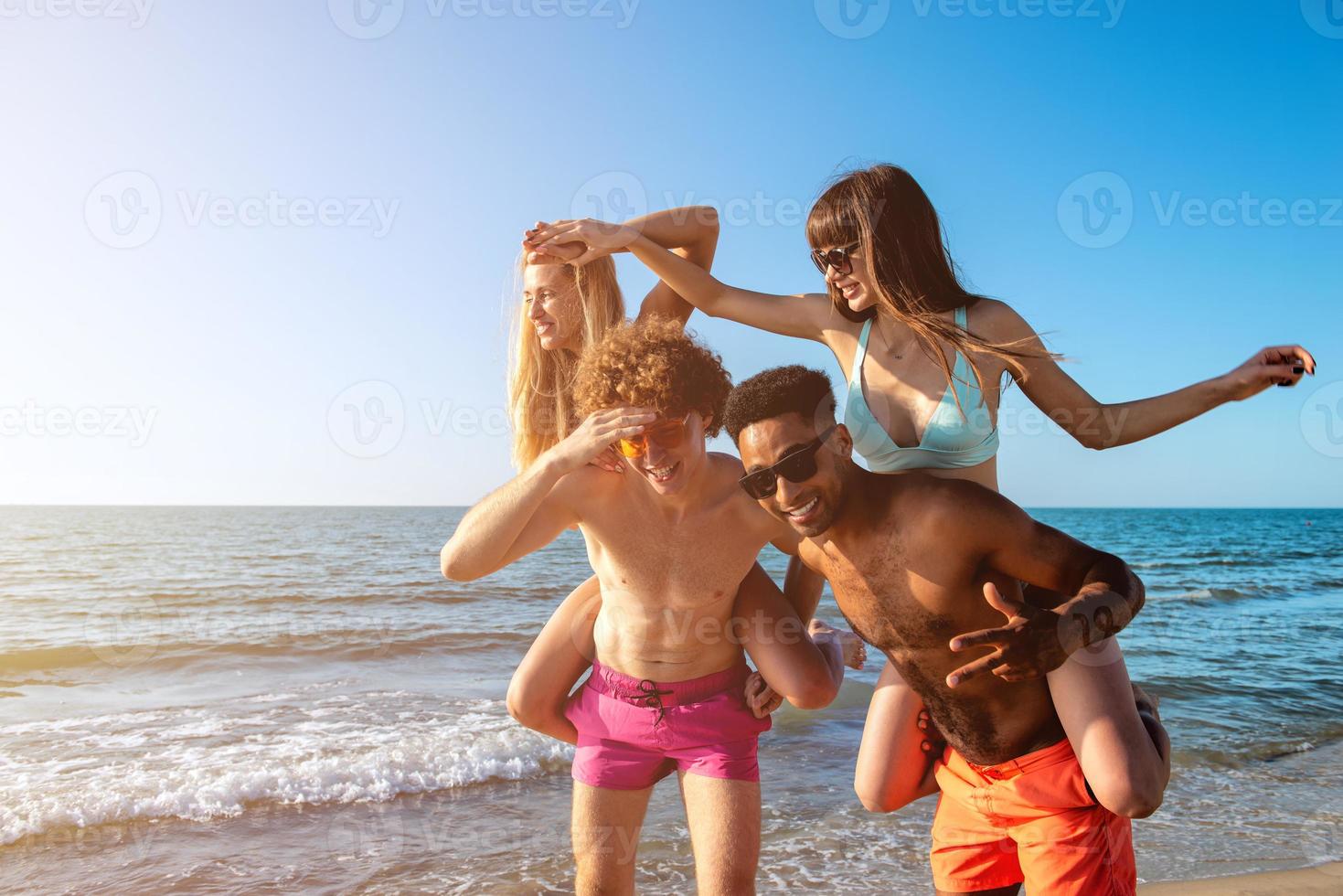Happy smiling couples playing at the beach photo