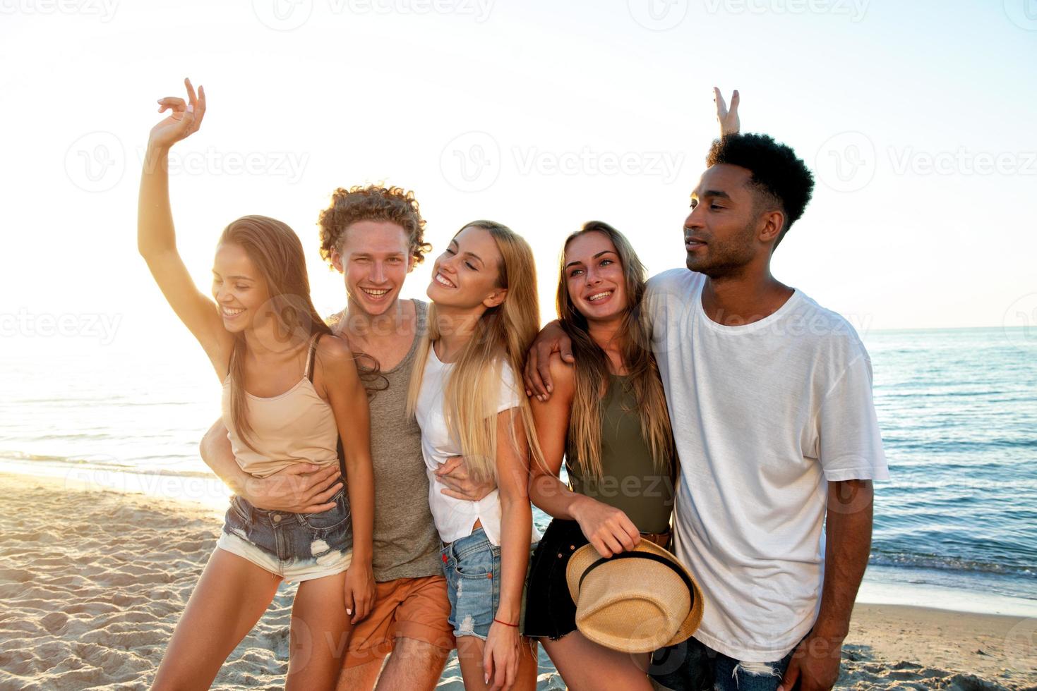 Group of friends having fun on the beach. Concept of summertime photo