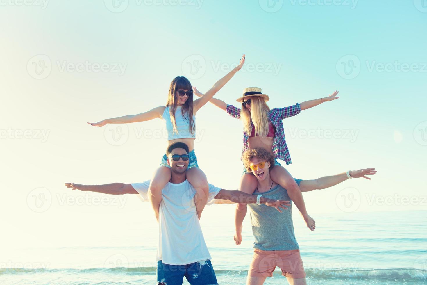 Happy smiling couples playing at the beach photo