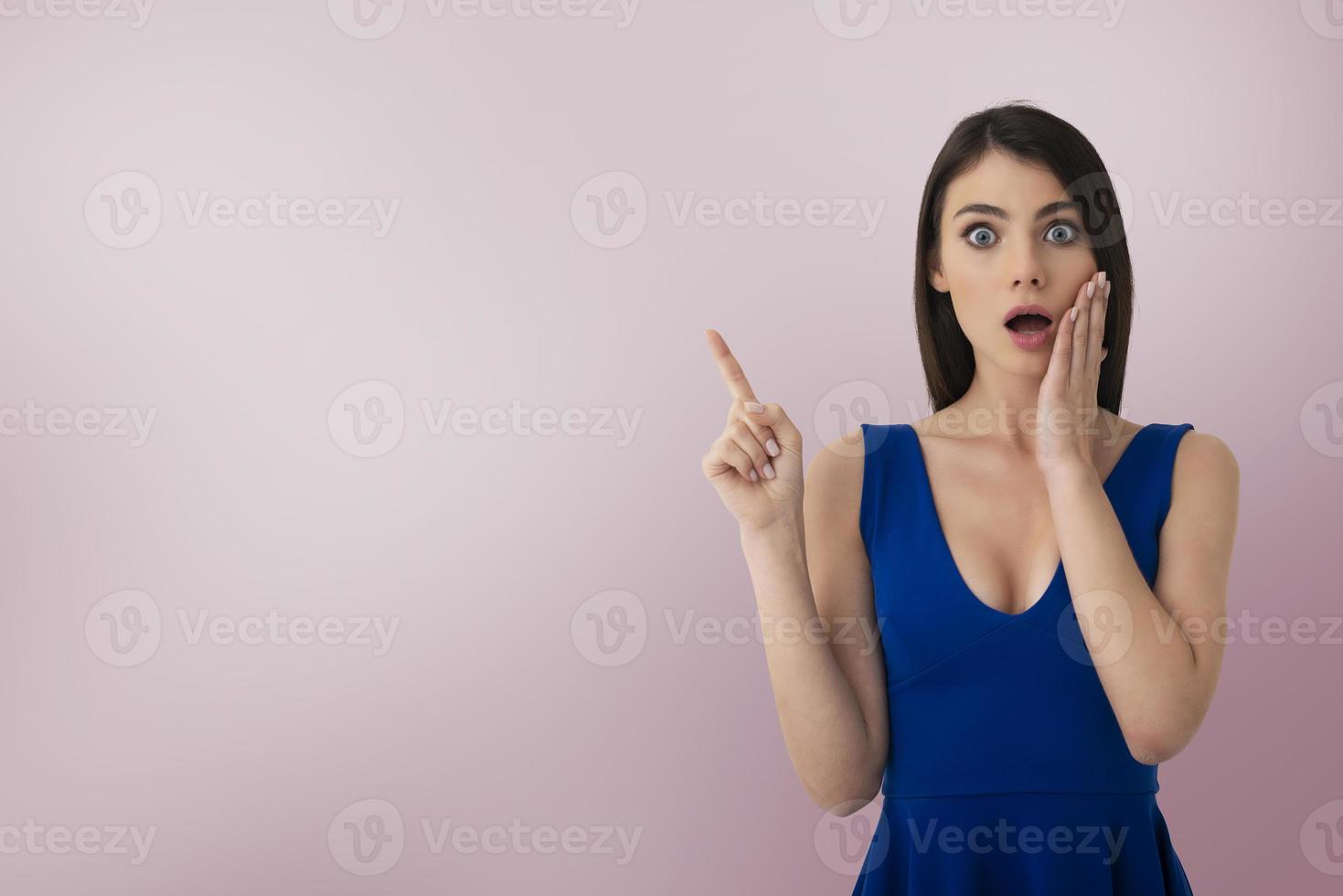 Surprised girl indicates a blank space for your text photo