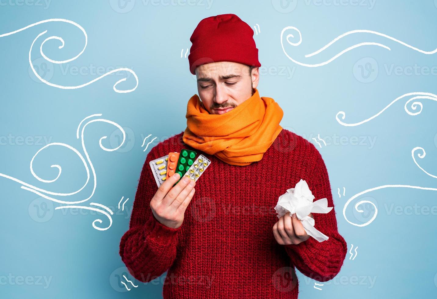 Boy caught a cold and uses pills to heal. Studio on Cyan background photo