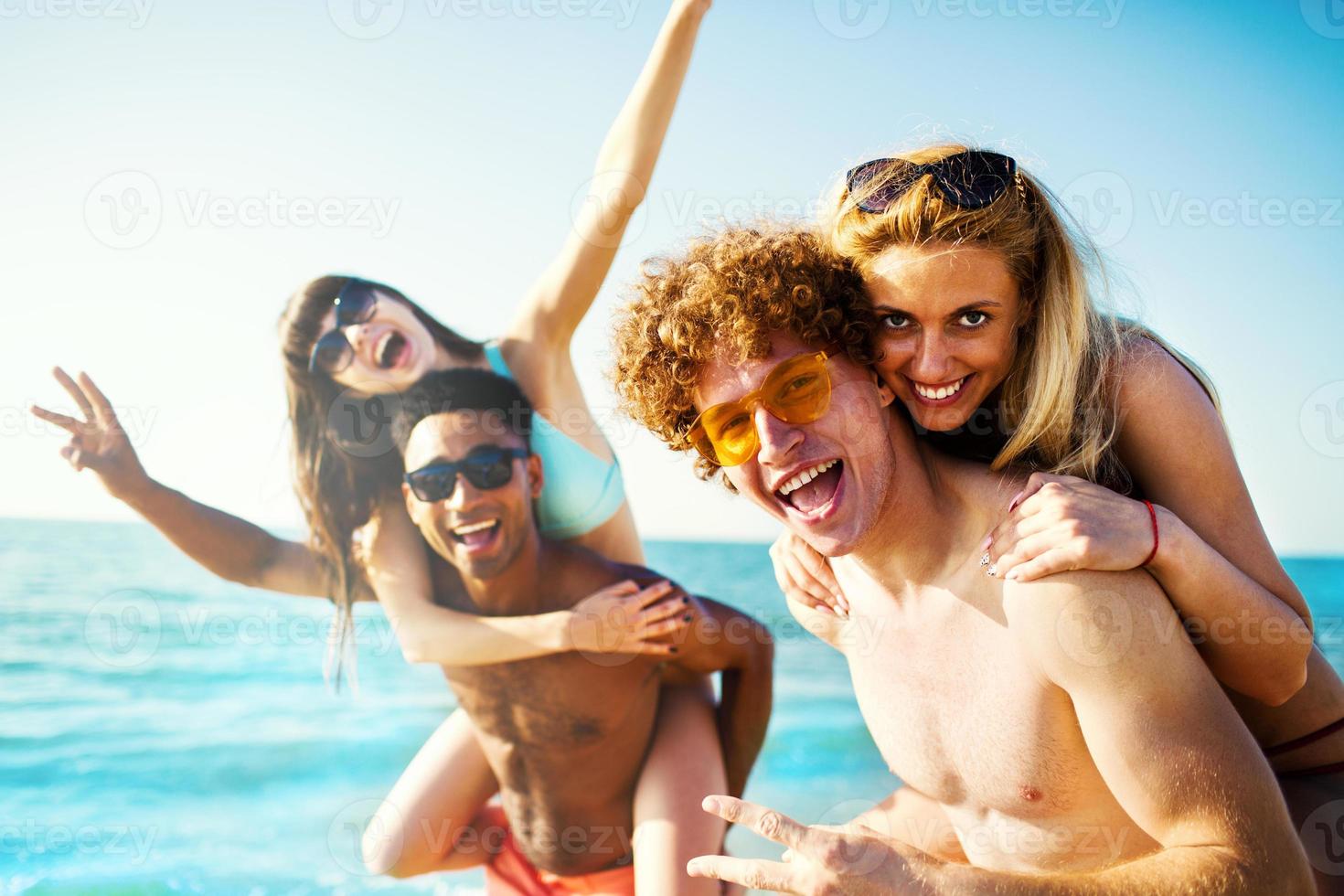 Happy smiling couples playing at the beach photo