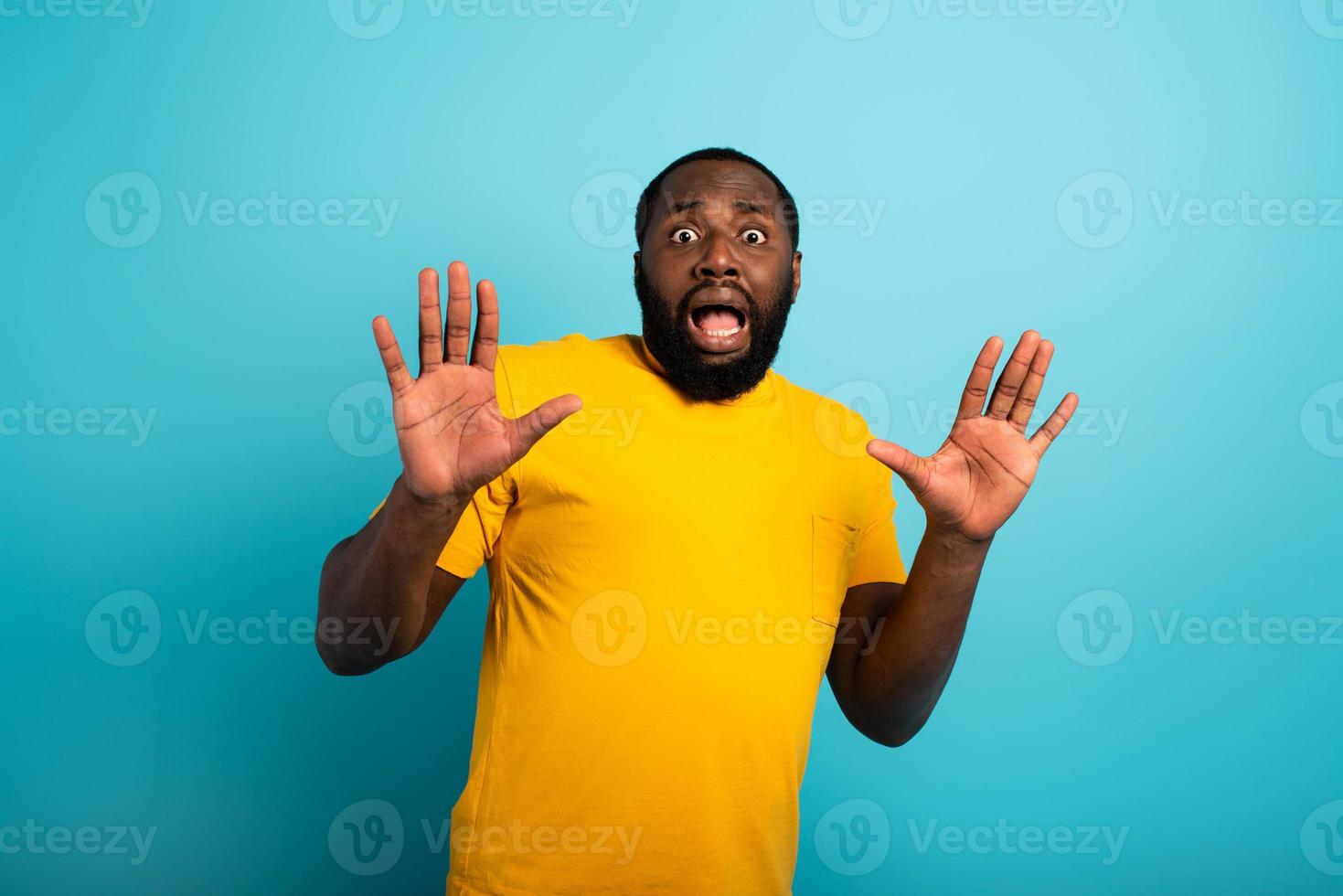 Fearful expression of a boy who is scared to catch the coronavirus. Cyan background. photo