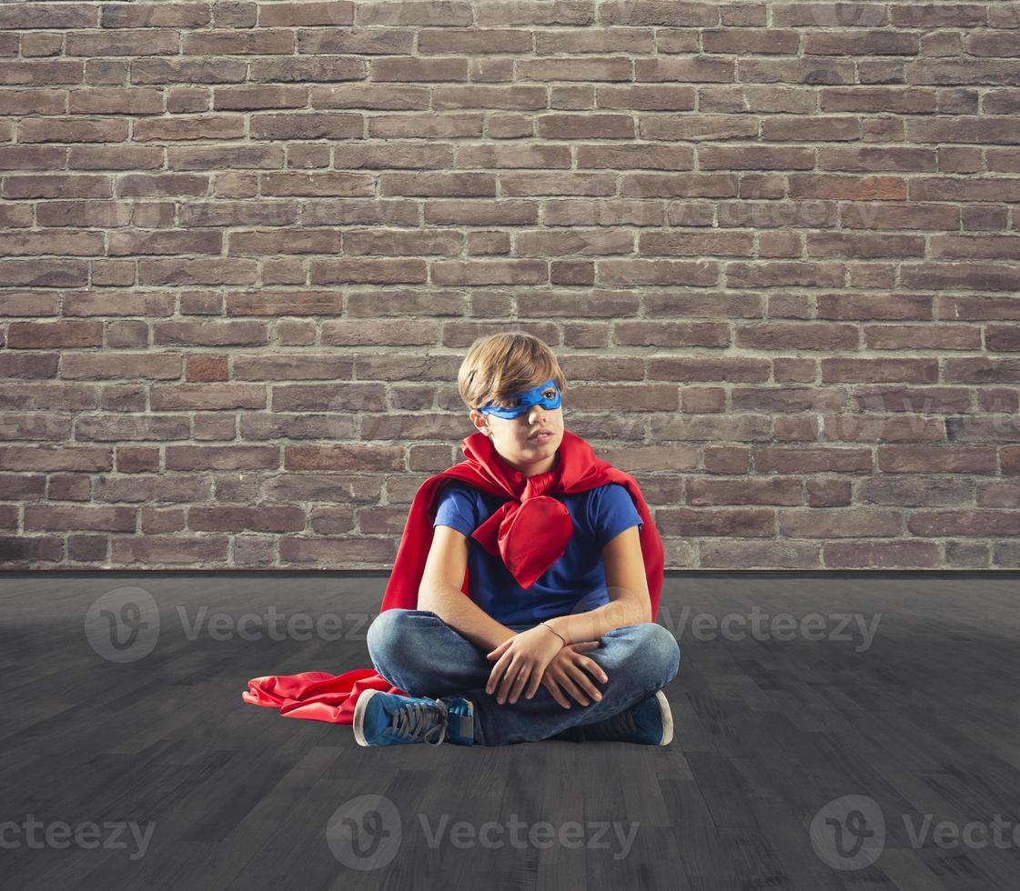 superhéroe niño sentado en un pared ese Sueños foto