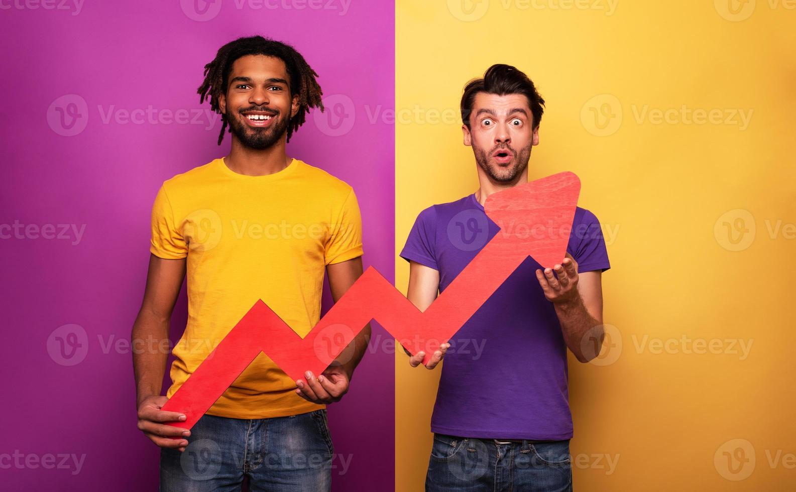 Amazed friends with funny face expression and red arrow statistic. Concept of growth, success, earn. photo