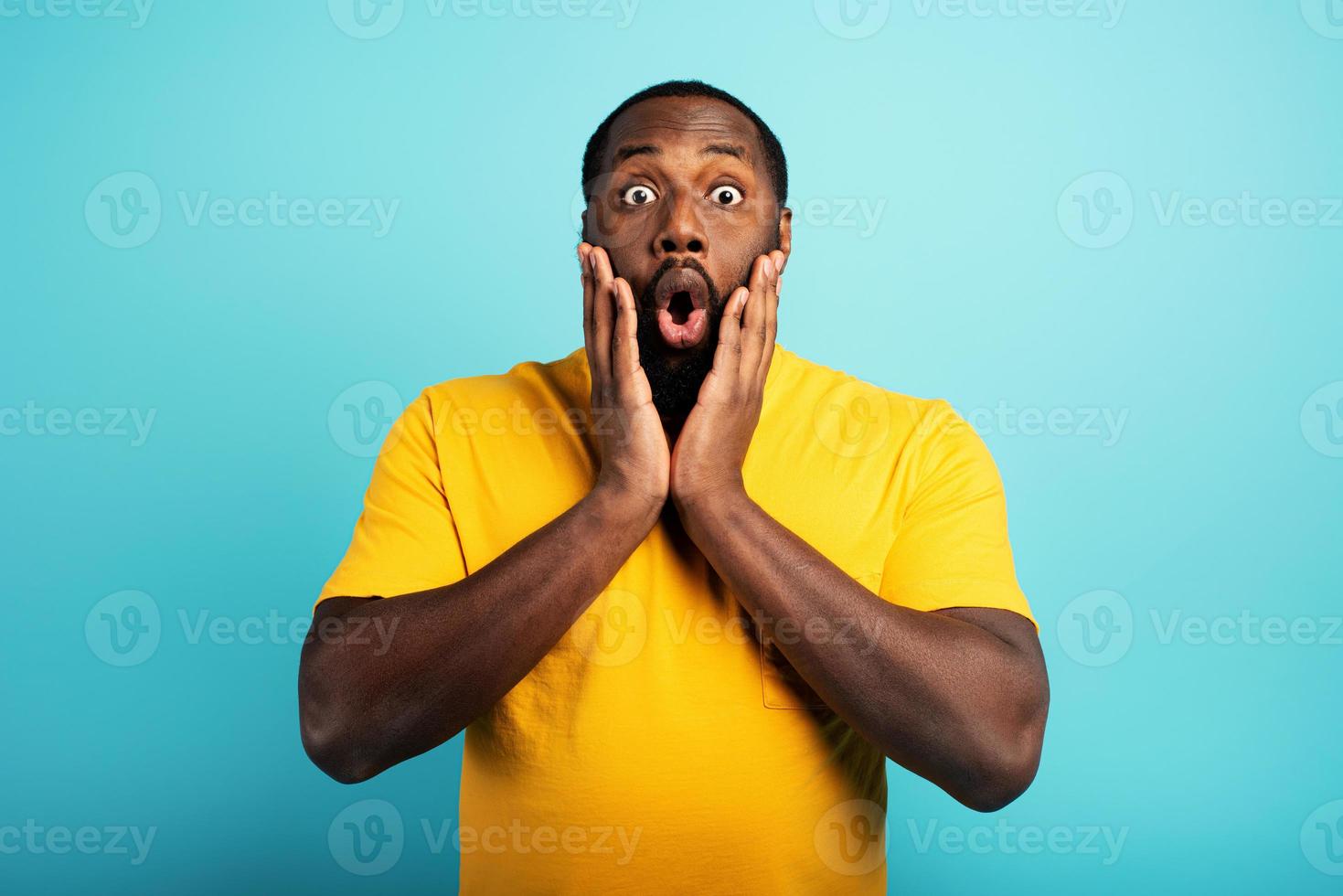 Amazed and shocked expression of a boy over cyan background photo